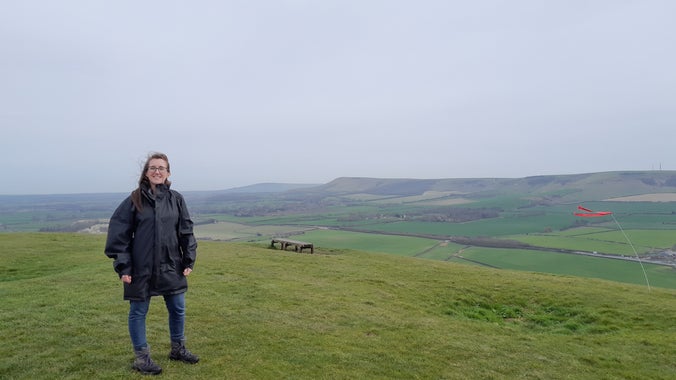 our archaeology apprentice, Kayleigh, up a hill on a very windy day